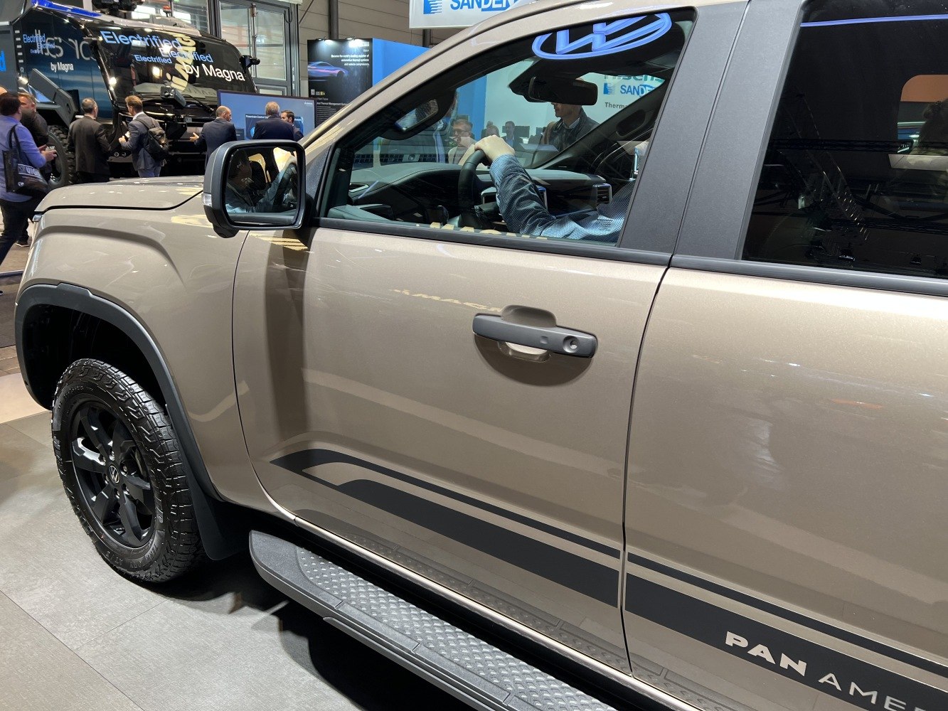 Close-up of pickup side door, black wheel, and step rail with Pan America detail