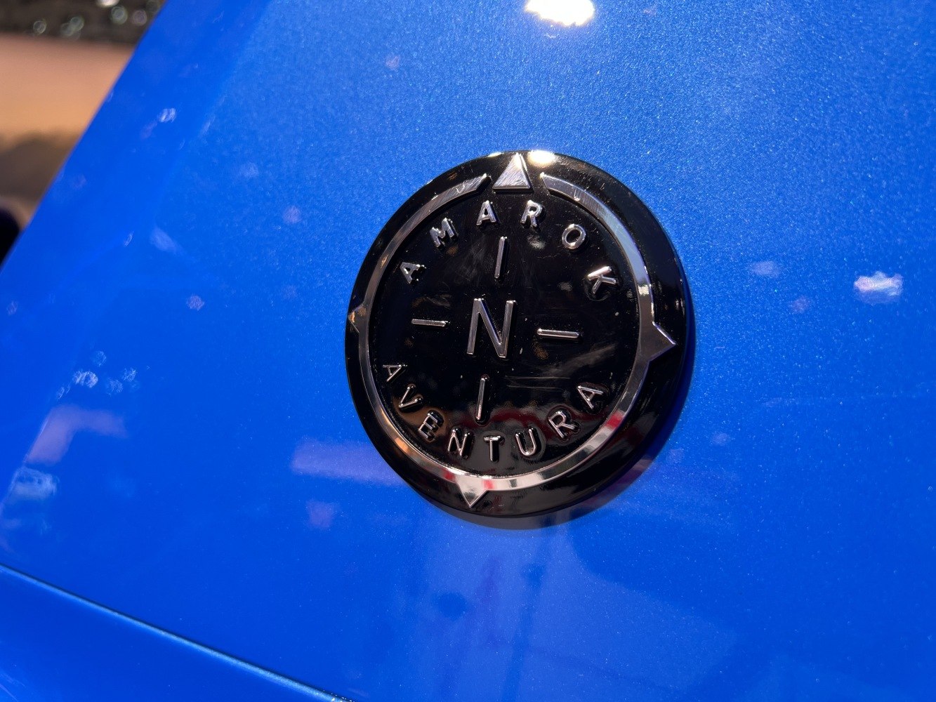 Close-up of Amarok Aventura badge on blue surface