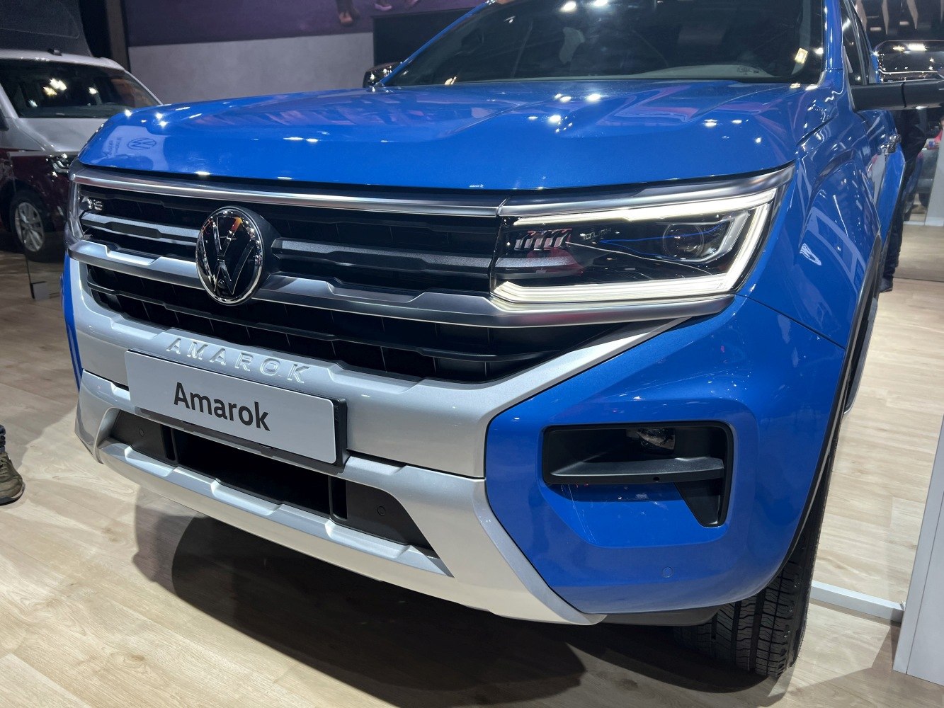 Close-up of grille and LED headlights on blue pickup.