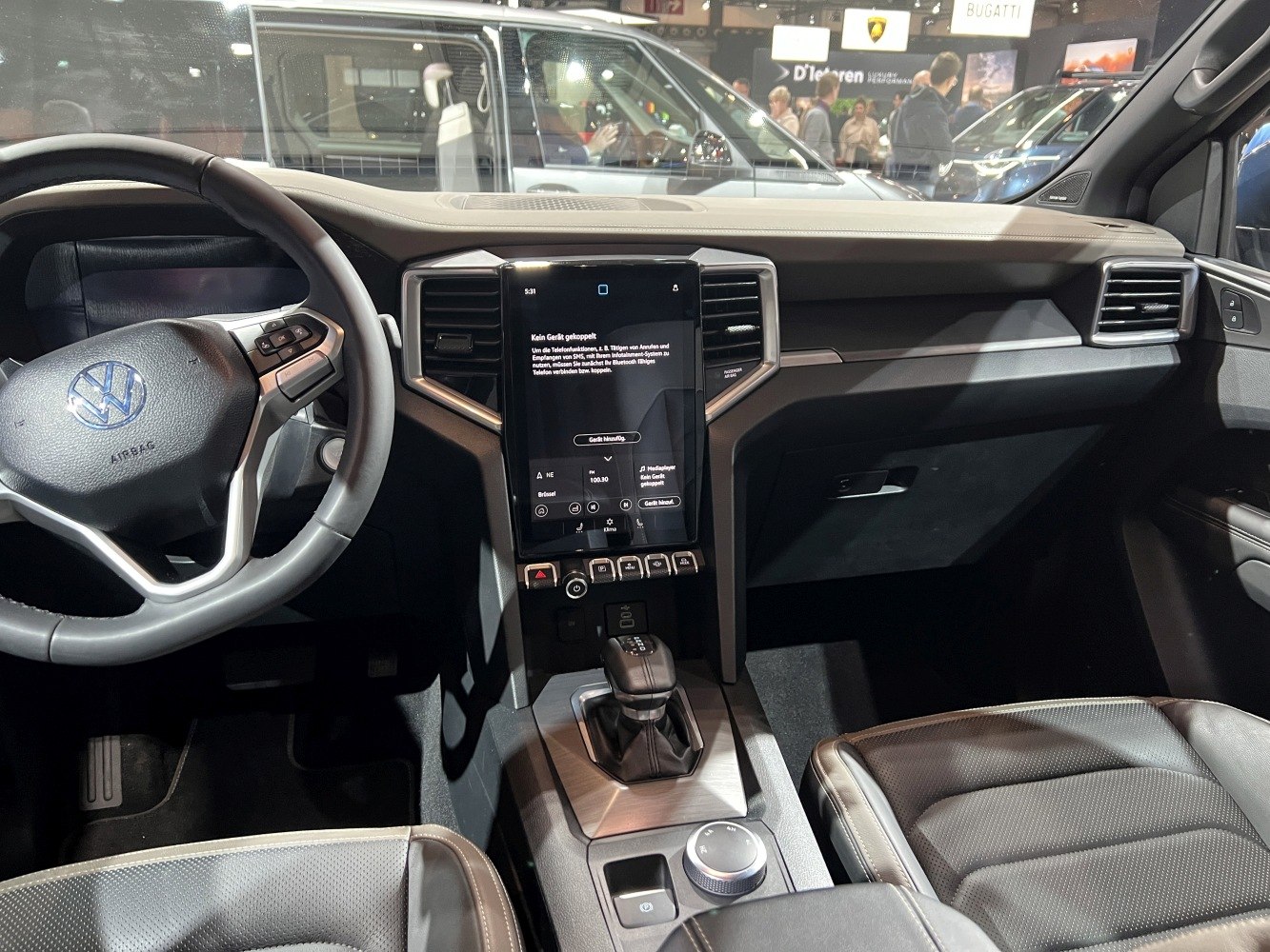 Touchscreen infotainment and multi-function steering wheel inside vehicle cabin