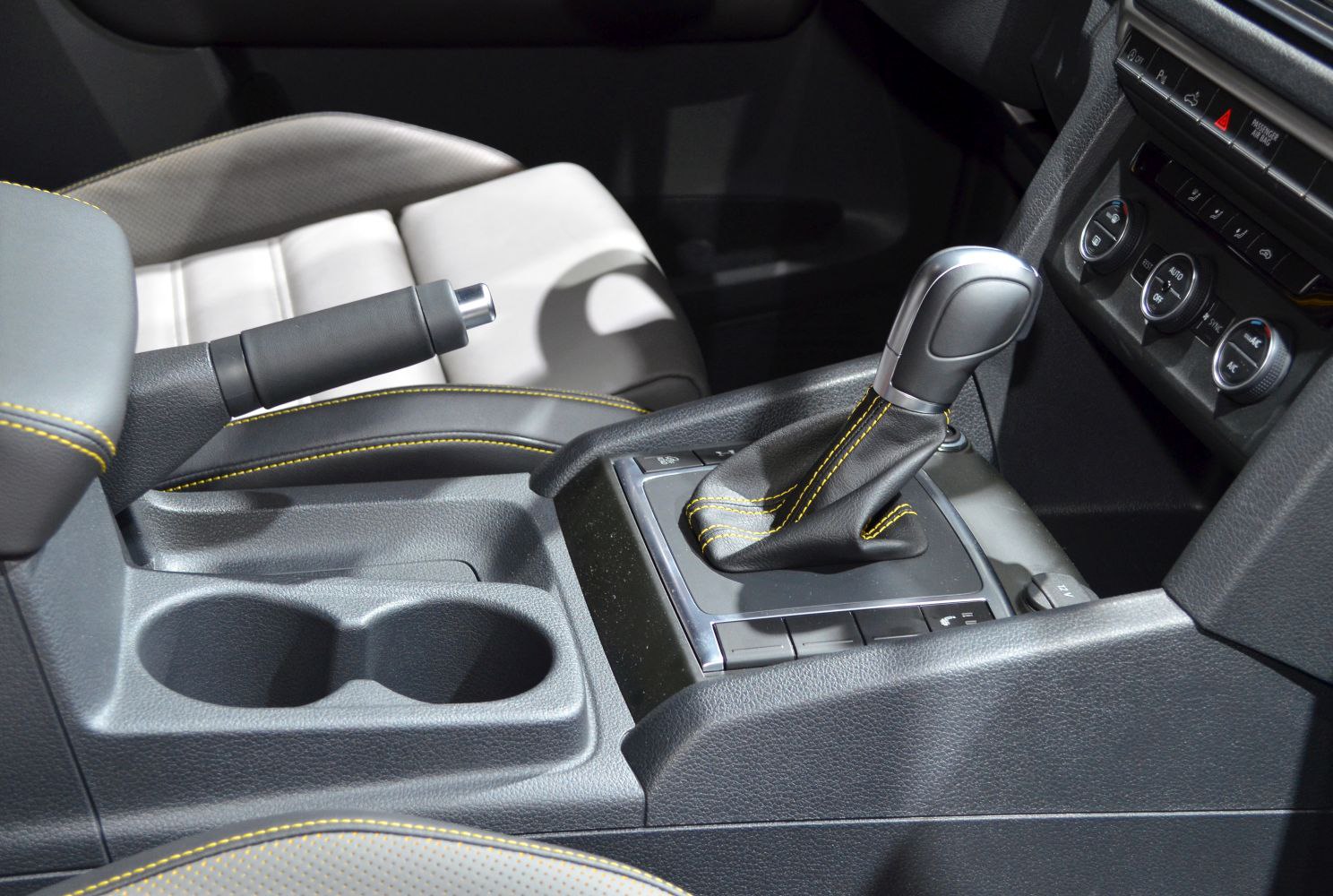 Gear shift lever and handbrake with yellow stitching in vehicle interior