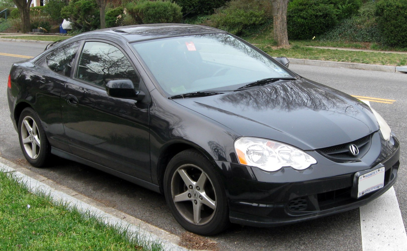 Black coupe with sunroof and alloy wheels parked on street
