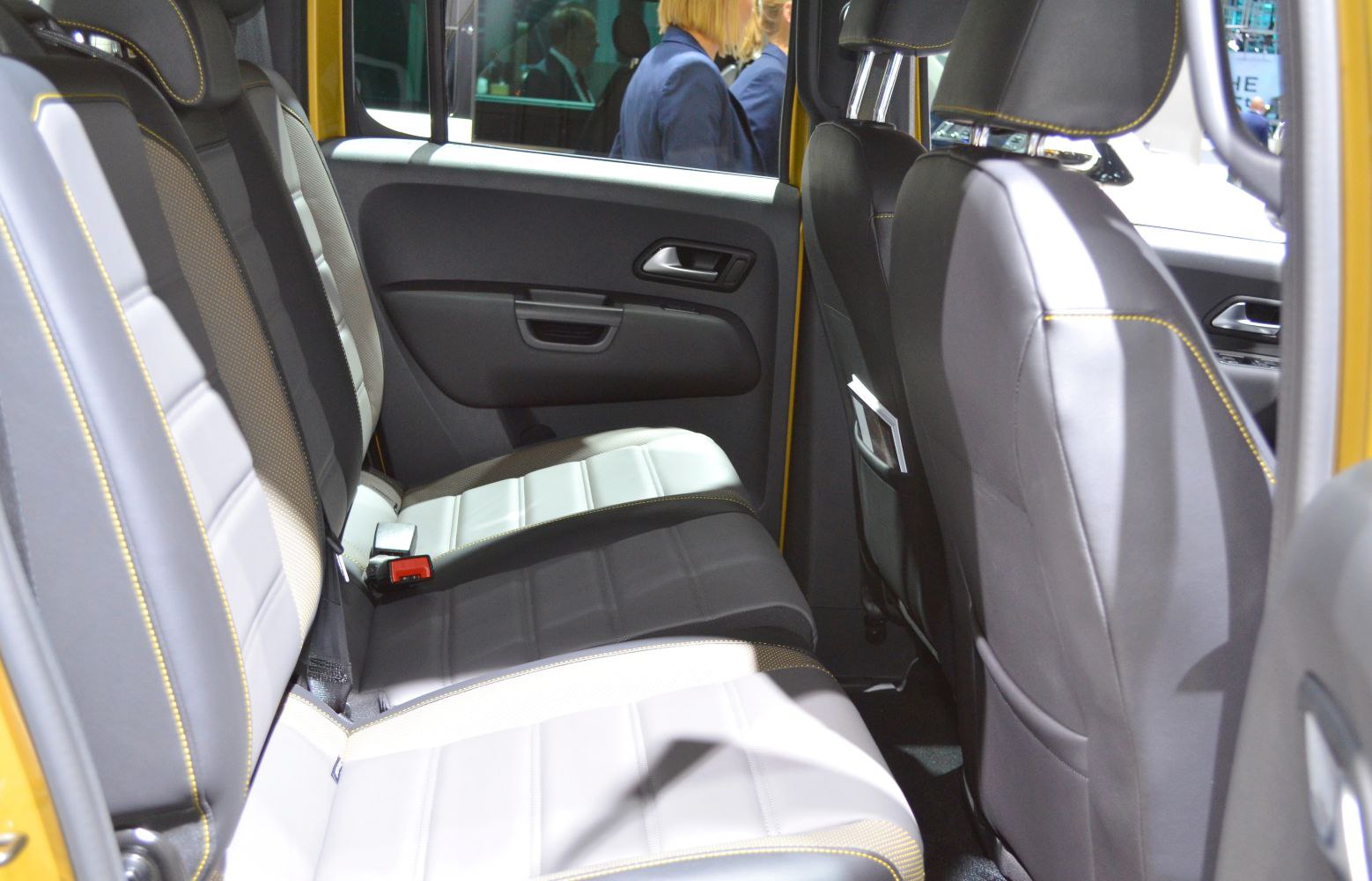 Rear seat interior with black and white upholstery and yellow stitching