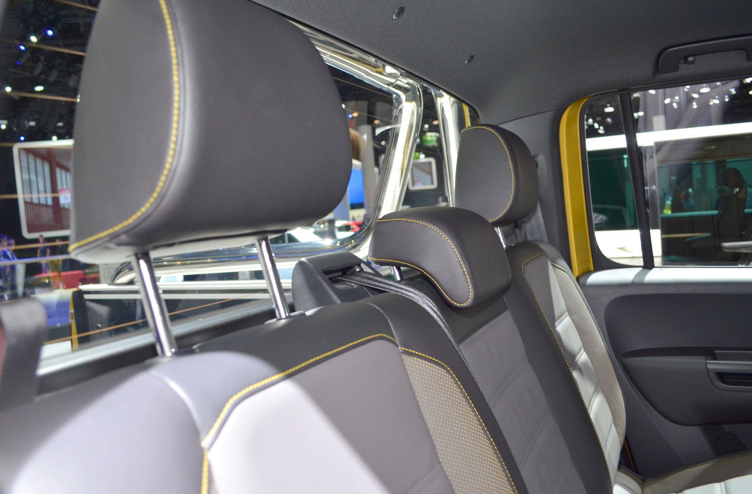 Rear seats with black upholstery and yellow stitching in pickup interior