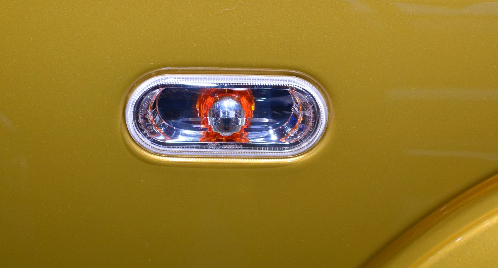 Close-up of yellow side indicator light on vehicle body
