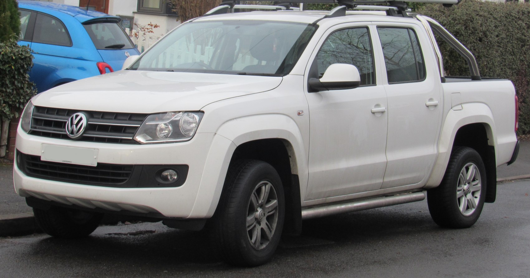 Double cab pickup truck with offroad tires, roof rails, and roll bar