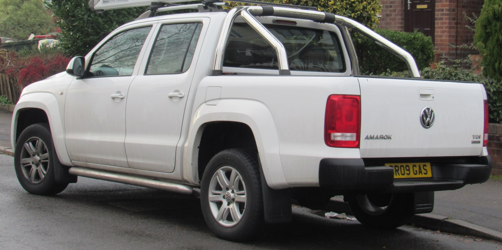 White pickup truck rear side with chrome roll bars and alloy wheels