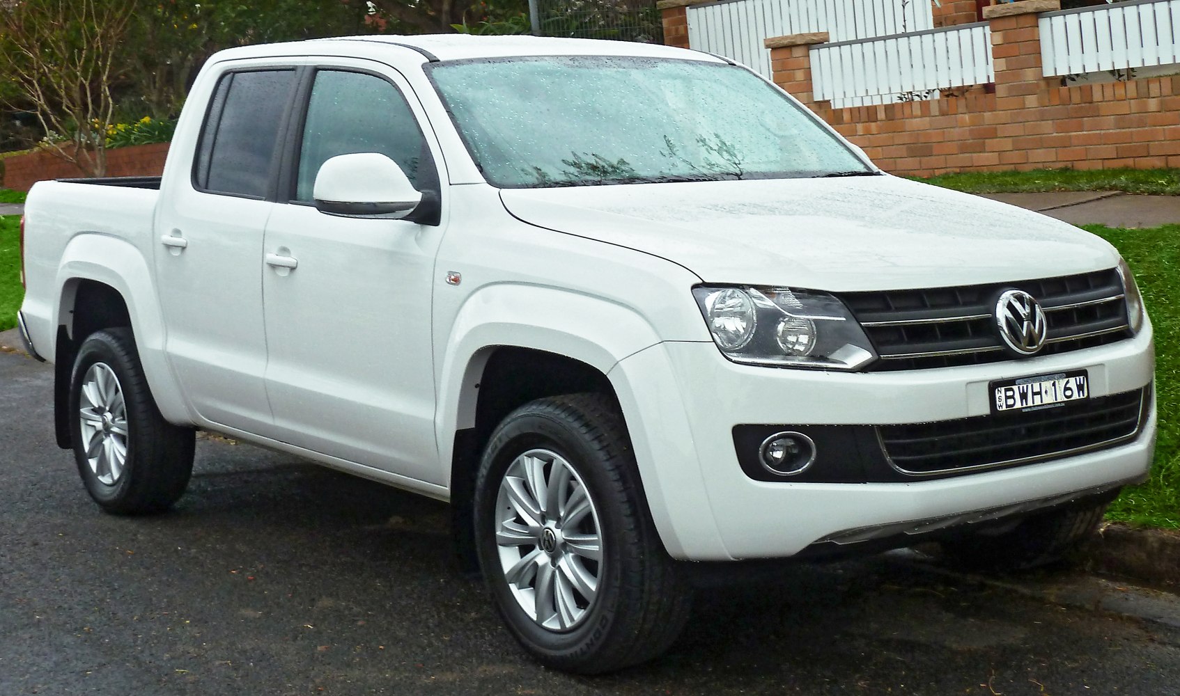 White double cab pickup with large headlights and alloy wheels