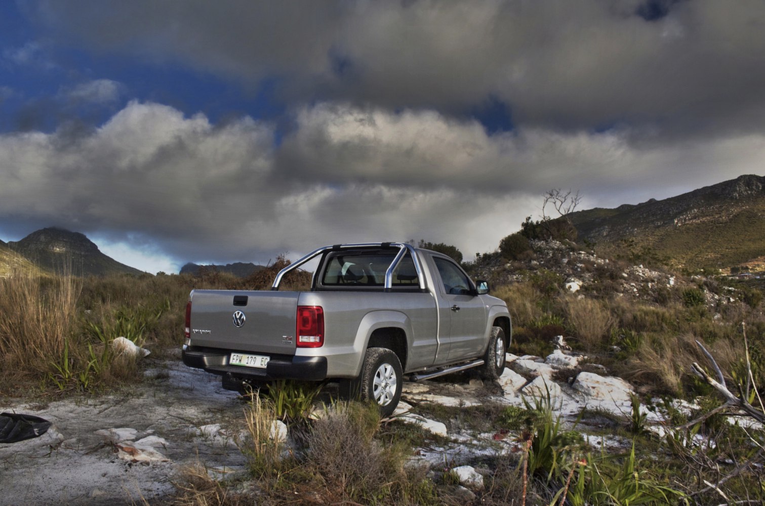 Rear and side view of single cab pickup in rugged terrain