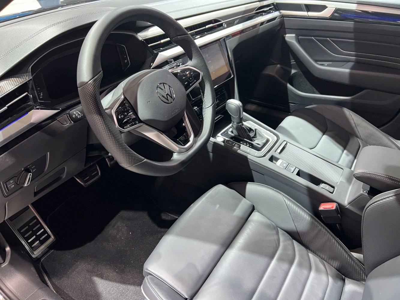 Multifunction steering wheel and gear shifter in a modern black leather car interior