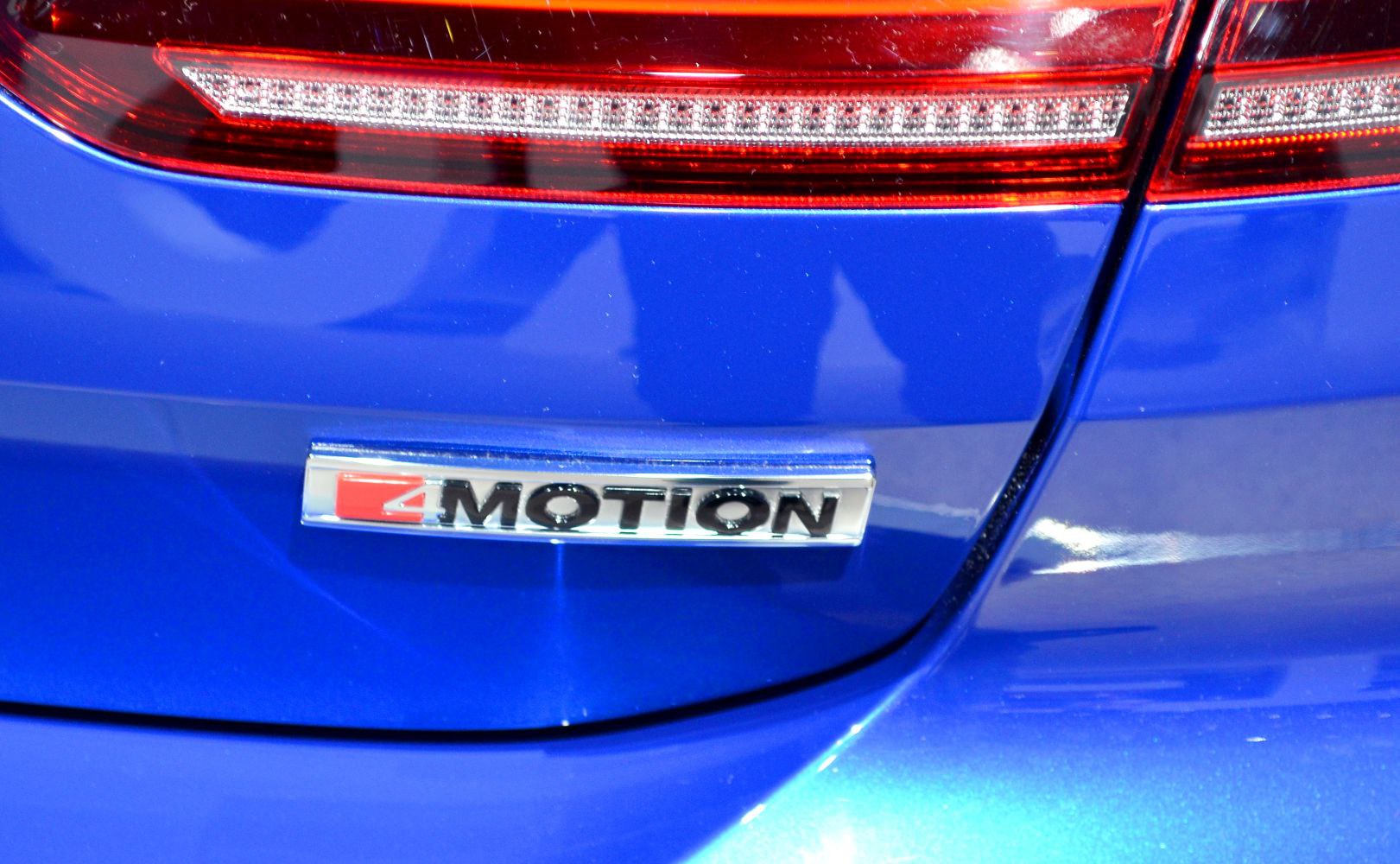 Close-up of rear 4MOTION badge and red taillight on blue vehicle body