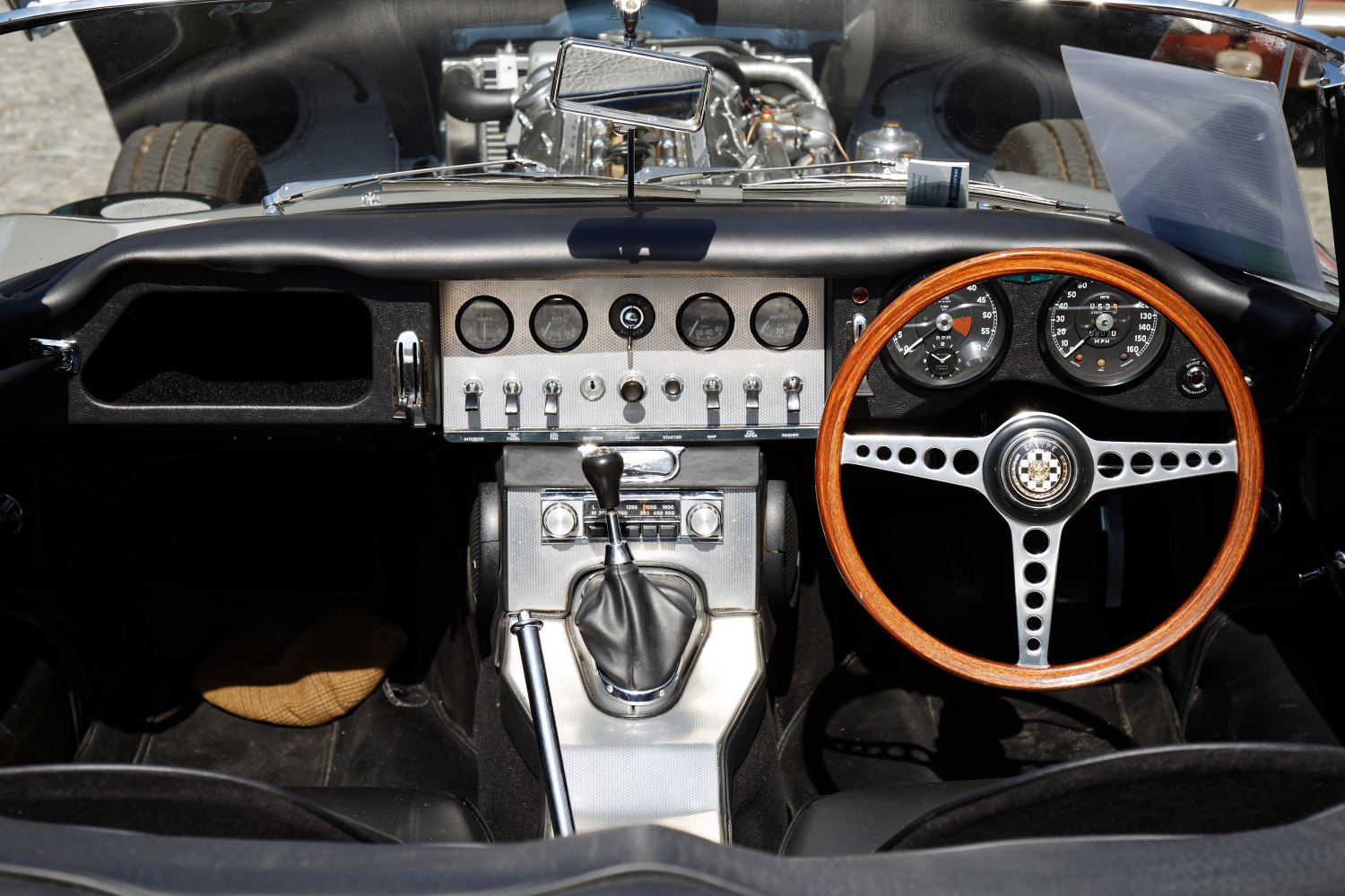 Wooden steering wheel and manual gear shift with vintage dashboard gauges