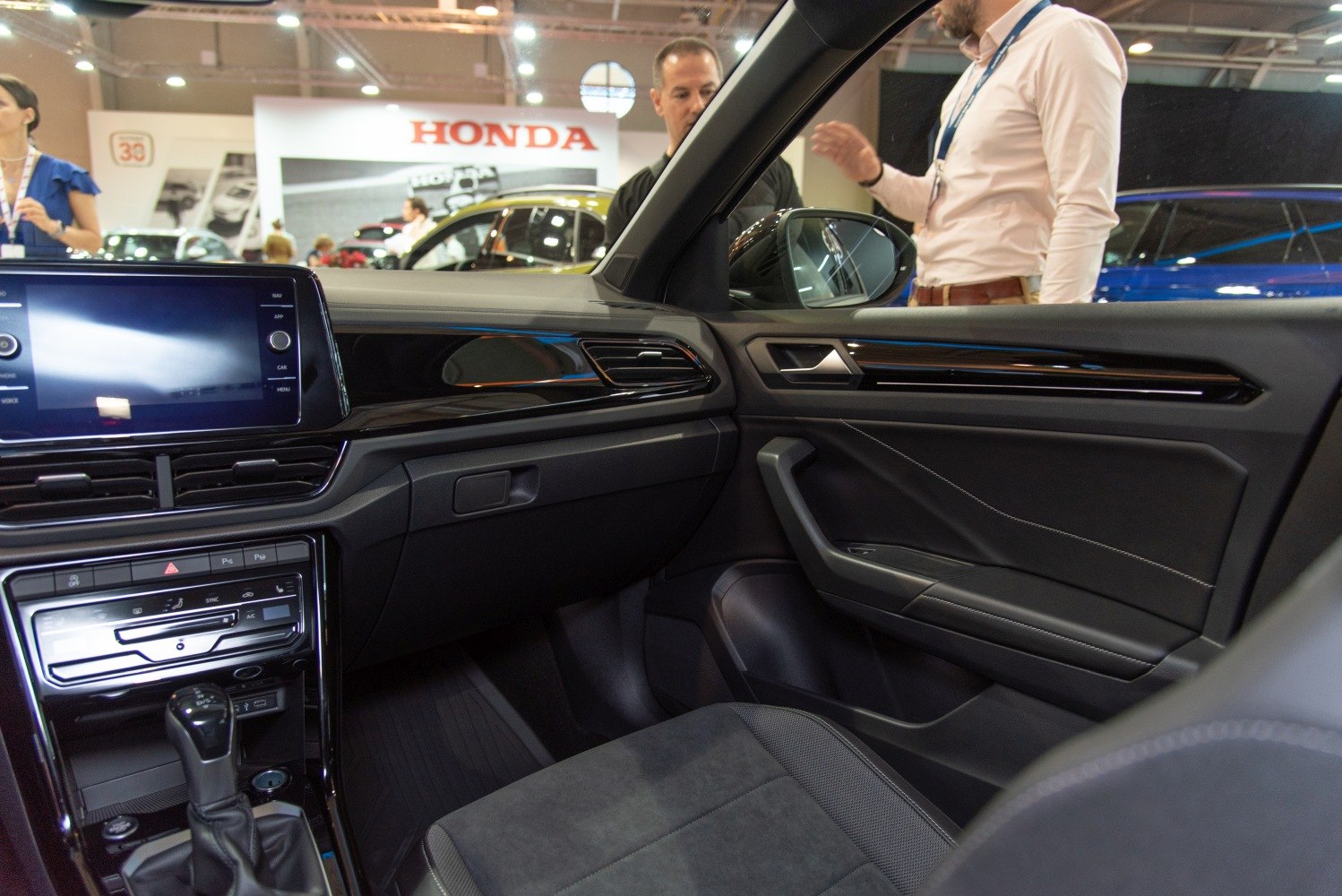Interior dashboard and door panel with gear shift and touchscreen.