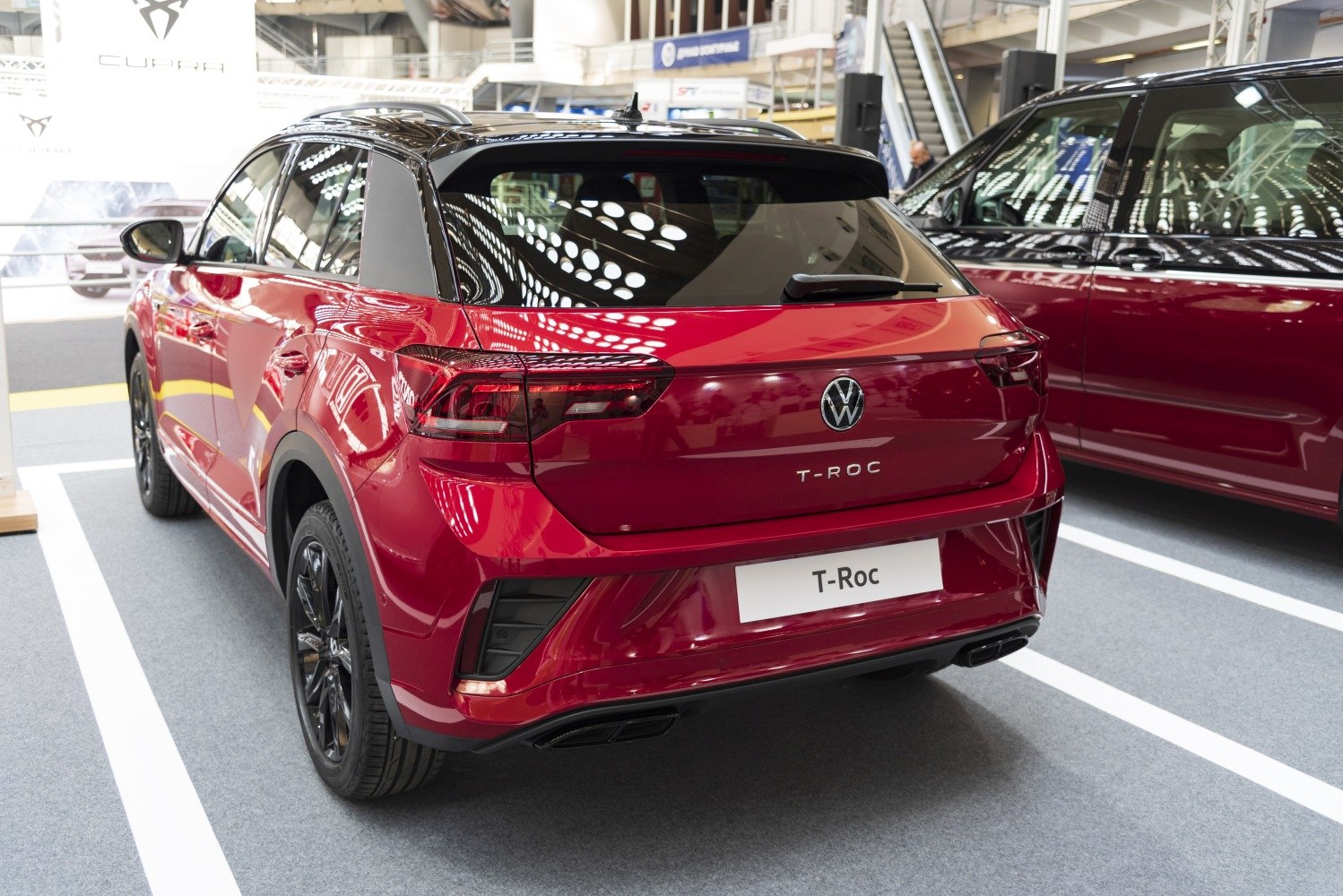 Red compact SUV rear with black roof, sleek taillights, and sporty dual exhaust pipes