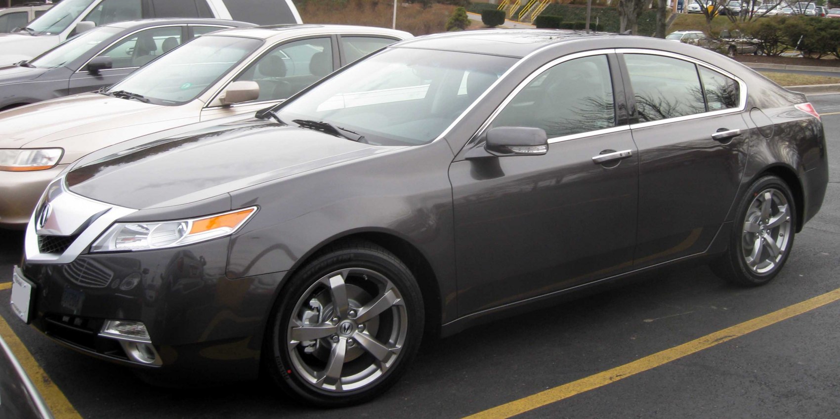 Dark sedan with chrome-accented front and alloy wheels