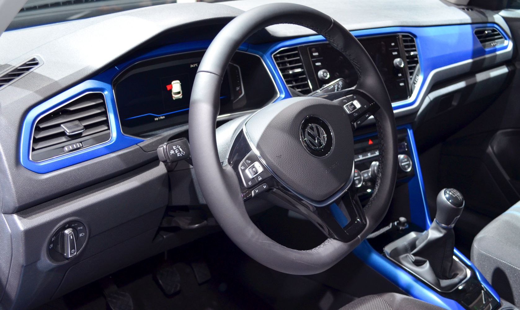 Dashboard and steering wheel with blue accents and manual gear shift