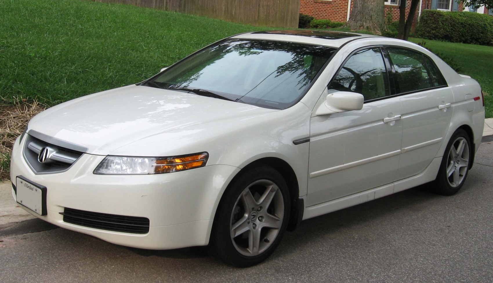 White sedan front side view with alloy wheels and distinctive headlights