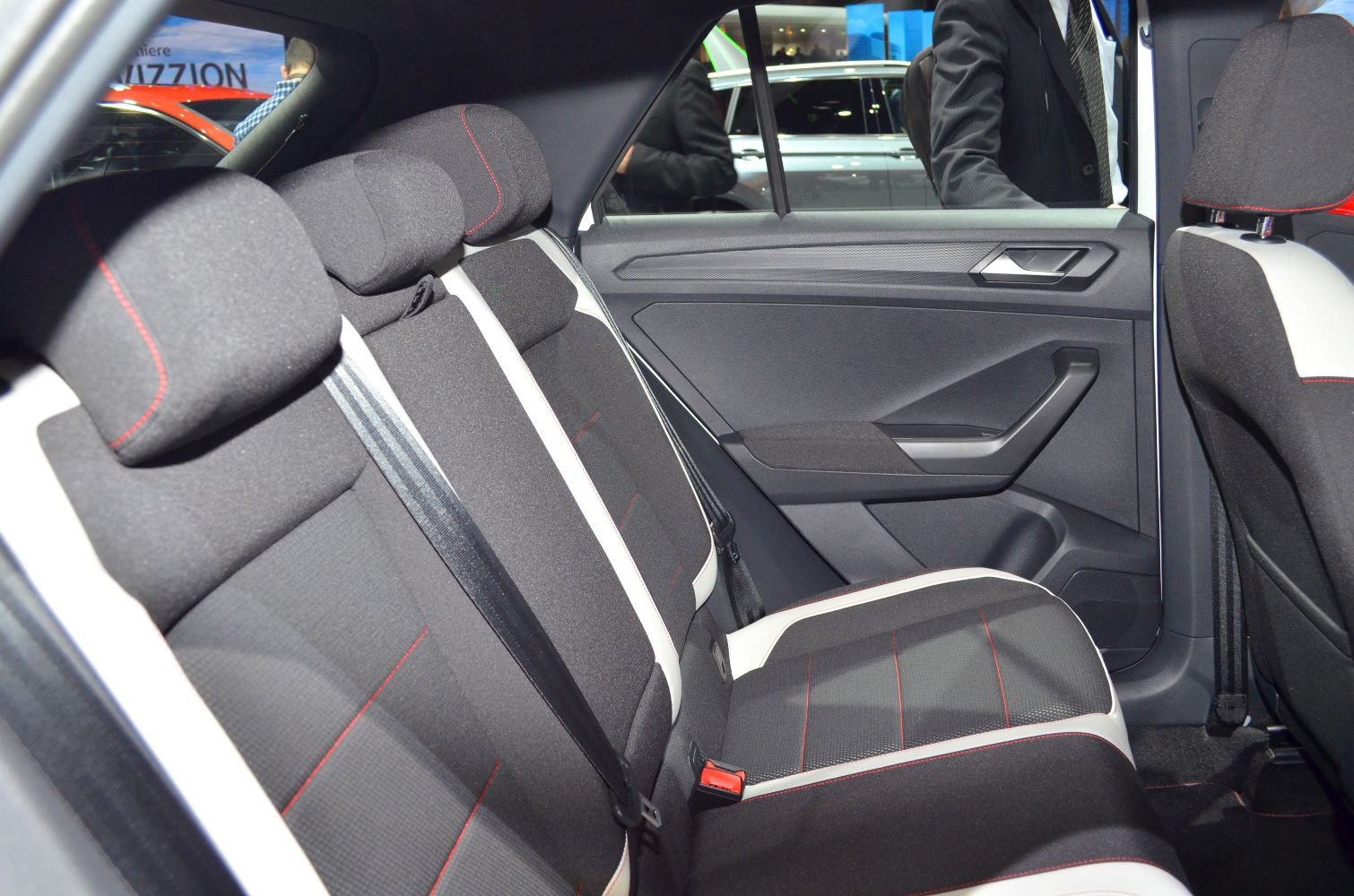 Rear seat fabric upholstery with red stitching, door panel design