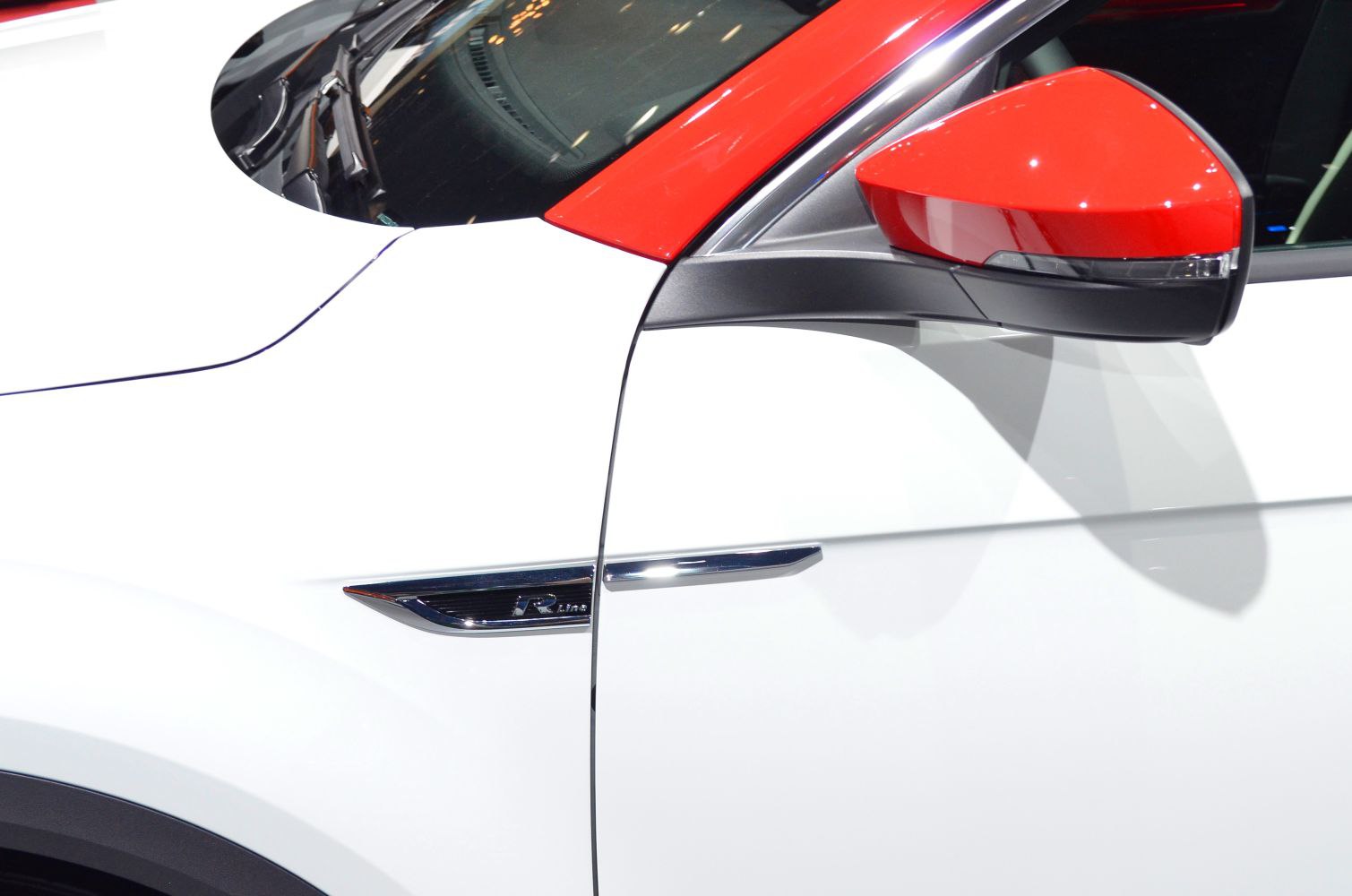 Red side mirror and R-Line badge on white vehicle