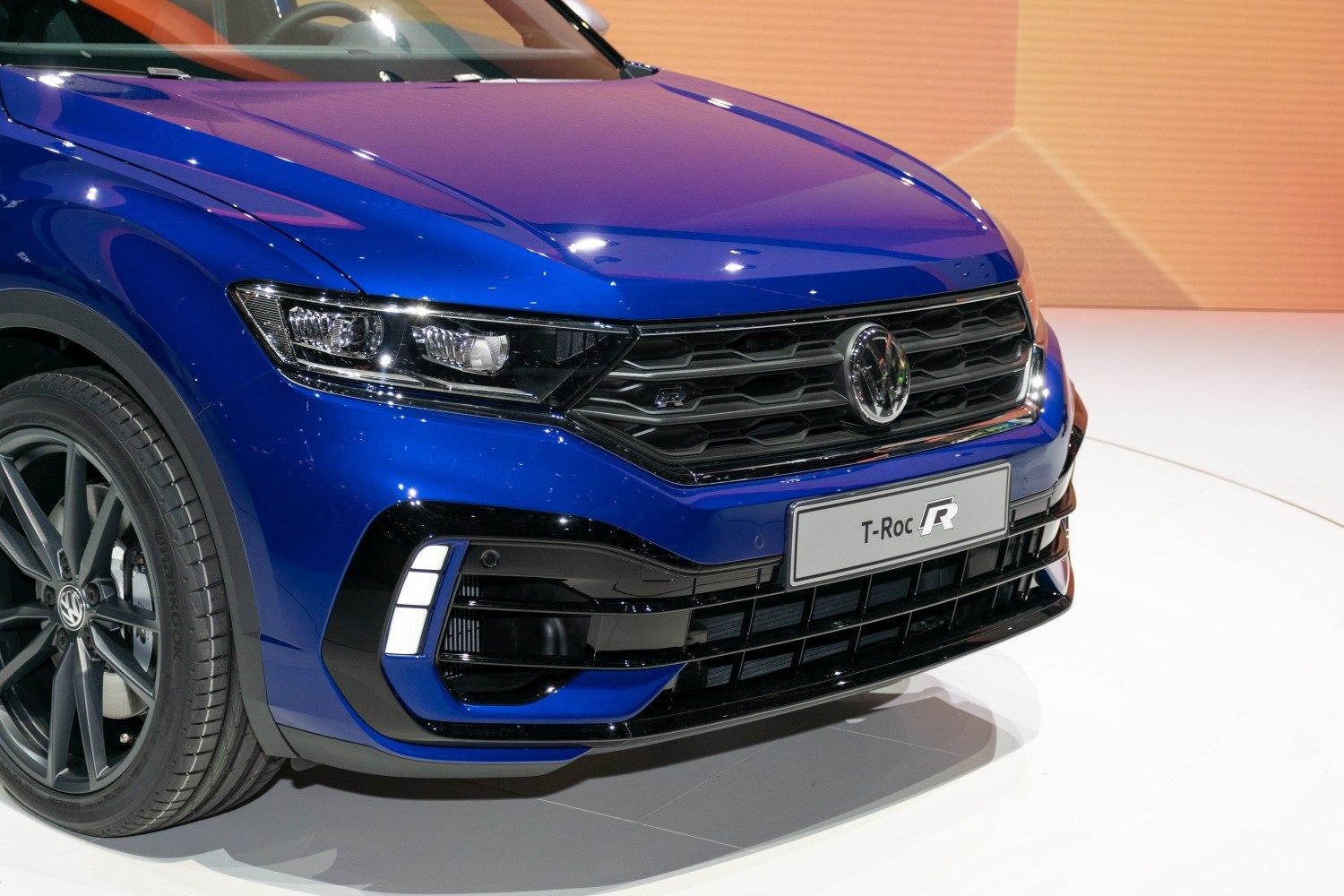 Close-up of front grille, headlight, and alloy wheel.