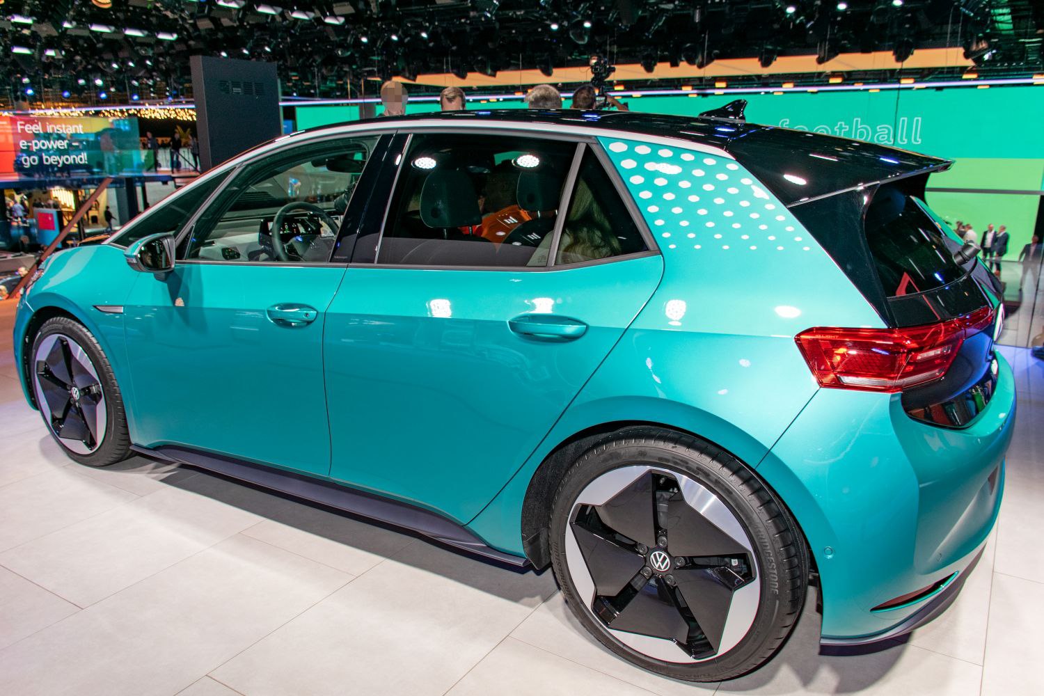Side profile with aerodynamic wheels of modern electric hatchback
