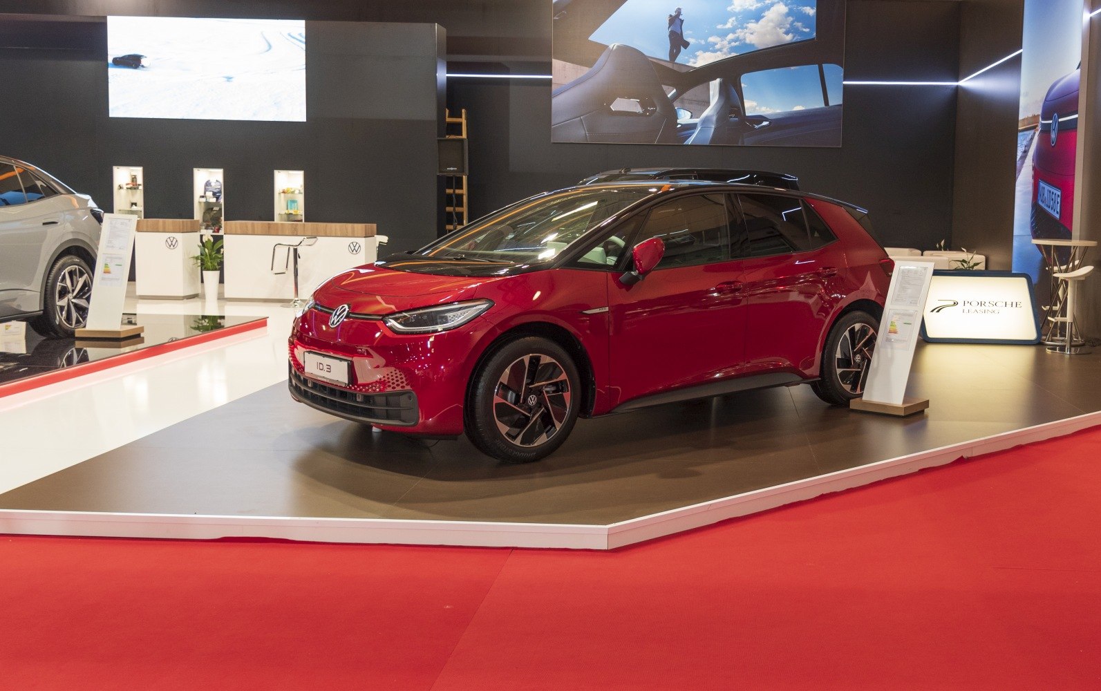 Red electric hatchback with aerodynamic design and distinctive headlights