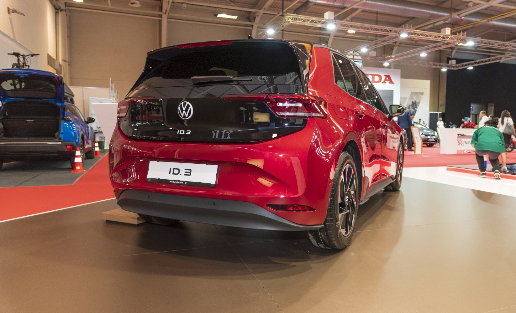 Rear view of a red electric hatchback with LED taillights and black rear panel