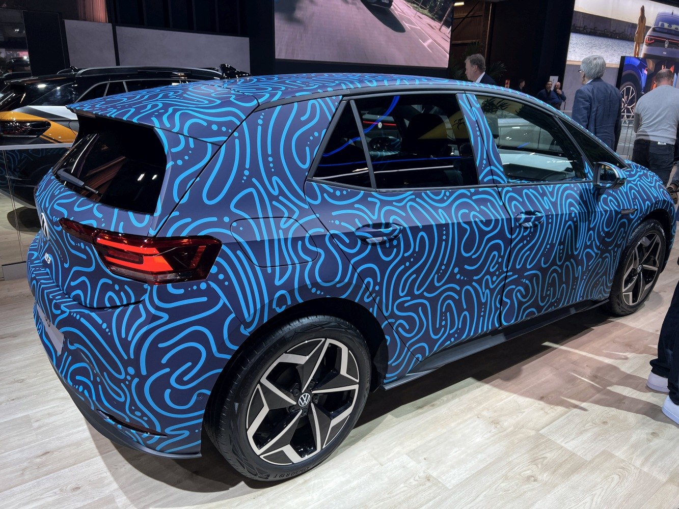 Electric hatchback with blue abstract pattern wrap and modern wheels