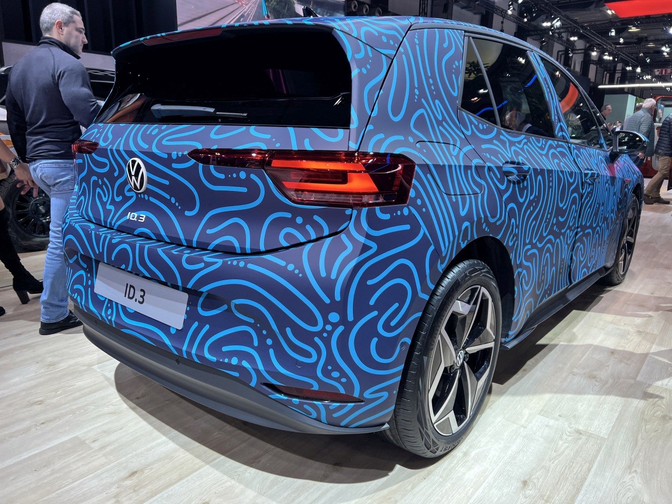 Rear and side view of electric hatchback with blue patterned wrap and LED taillights