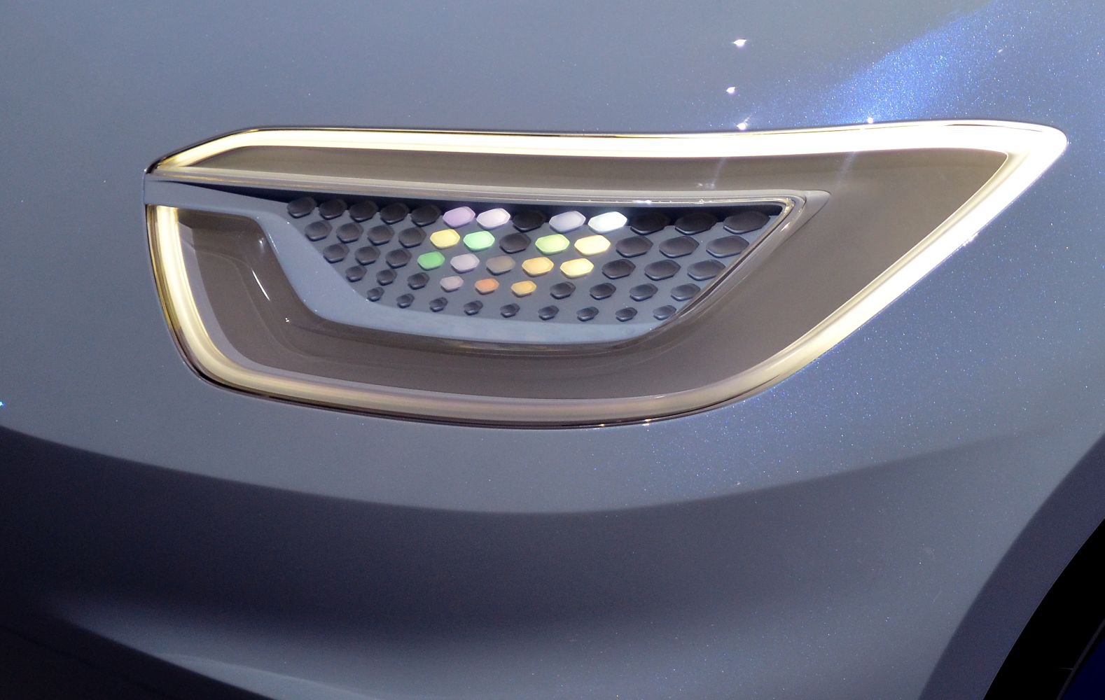 Front light with illuminated grille detail on futuristic electric concept car