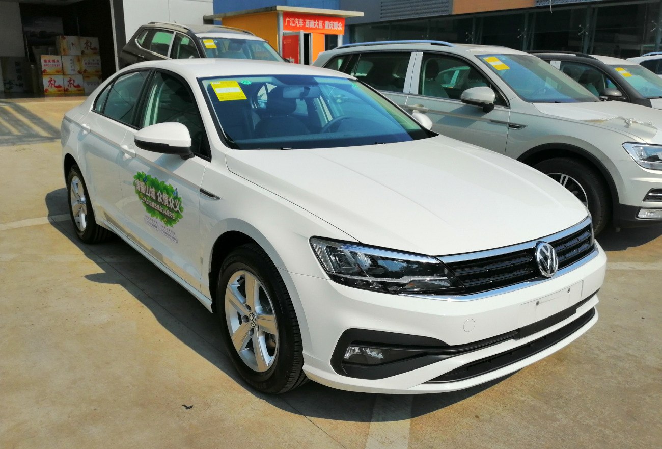 White sedan front-side view with modern headlights and alloy wheels
