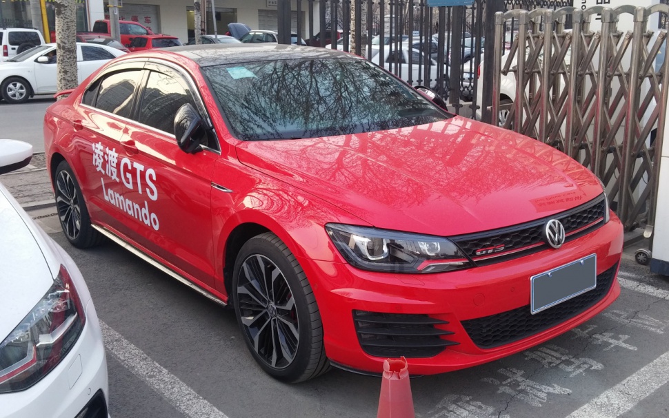 Sporty red sedan showing front side view with aggressive headlights and alloy wheels