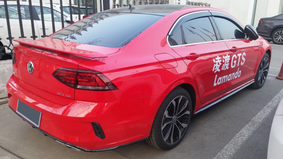 Red sedan rear with sporty spoiler and modern taillights