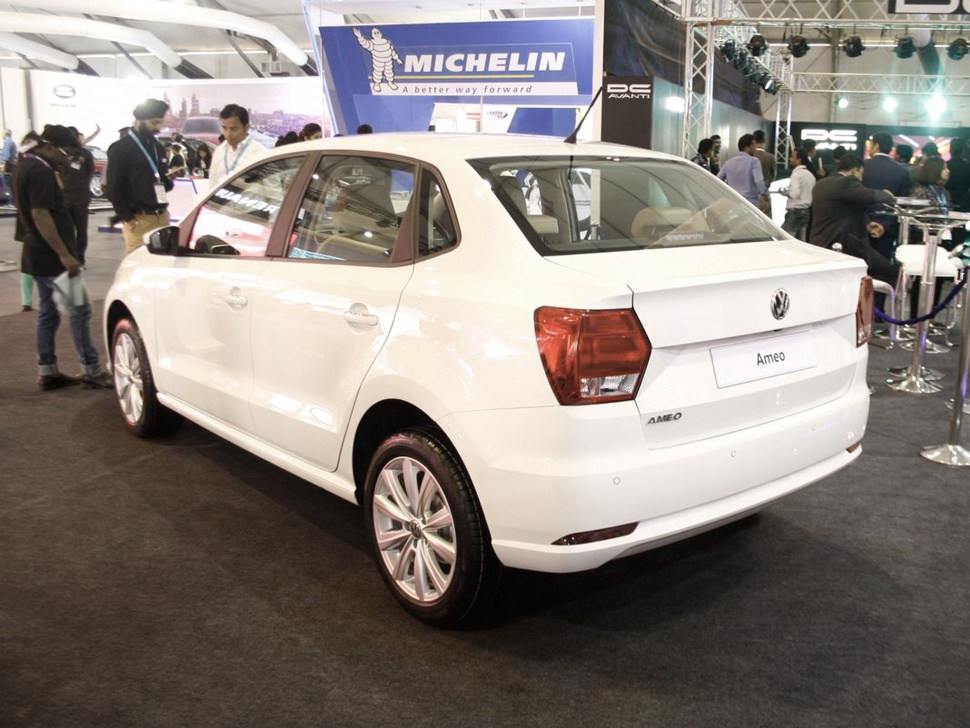 Rear and side view of a white compact sedan with distinct taillights and alloy wheels