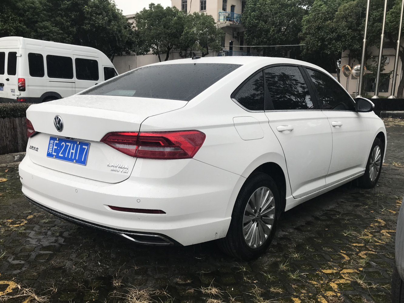 Rear and side view of white sedan with modern tail lights and alloy wheels