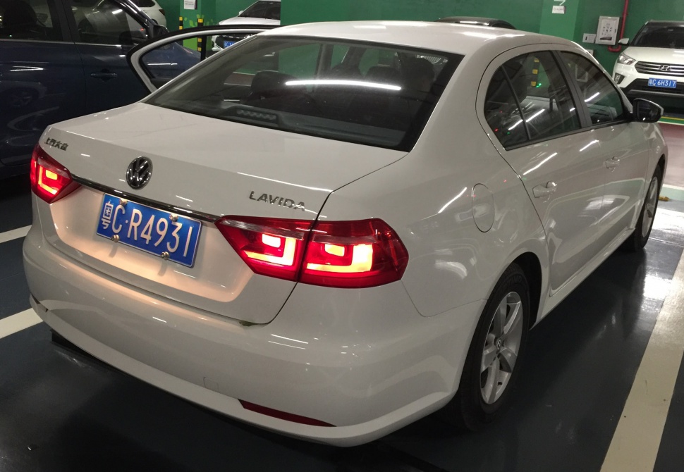 Rear view with illuminated distinct taillights and sedan body design.