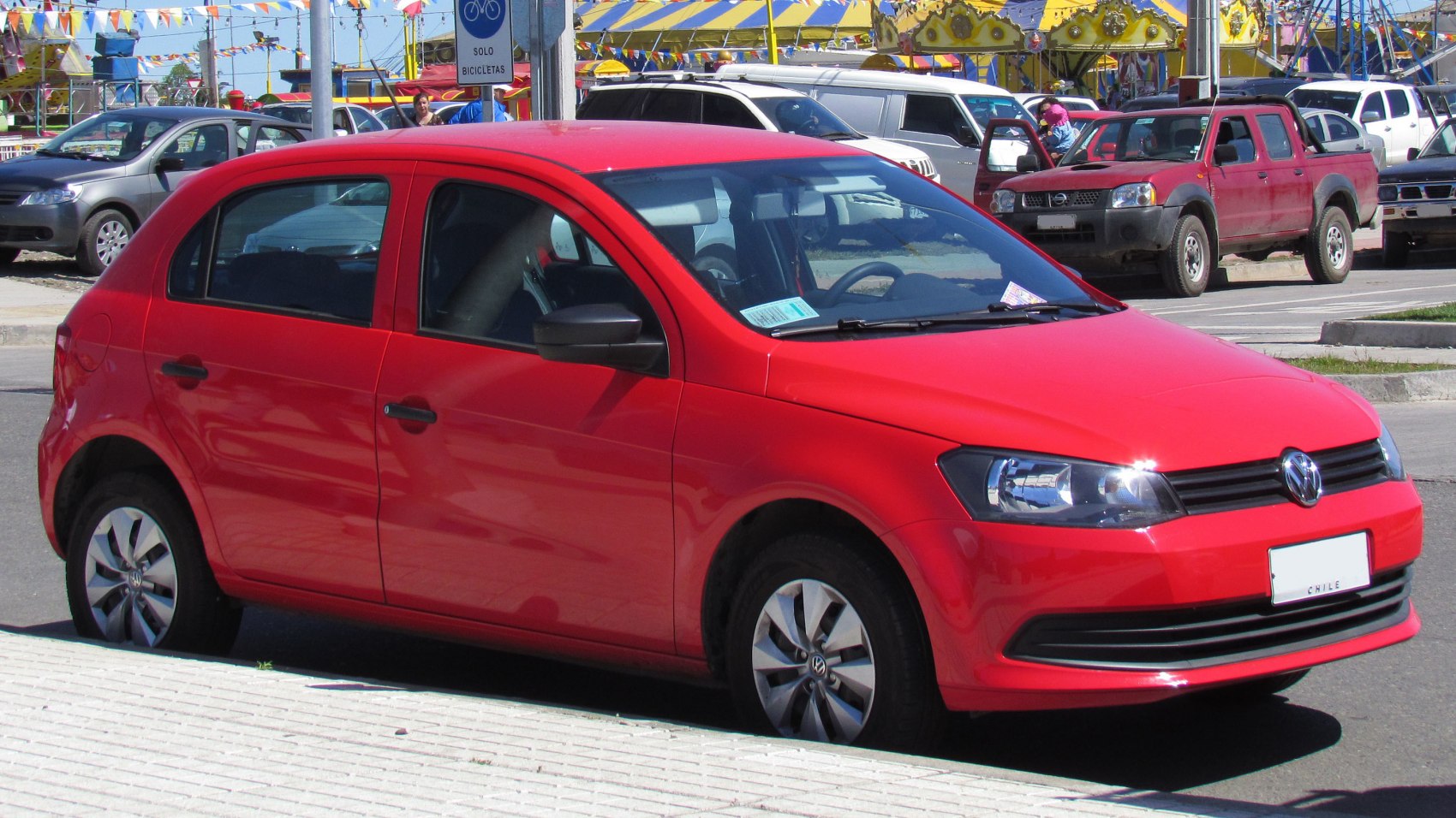 Red hatchback front side view with distinctive headlights and smooth body lines