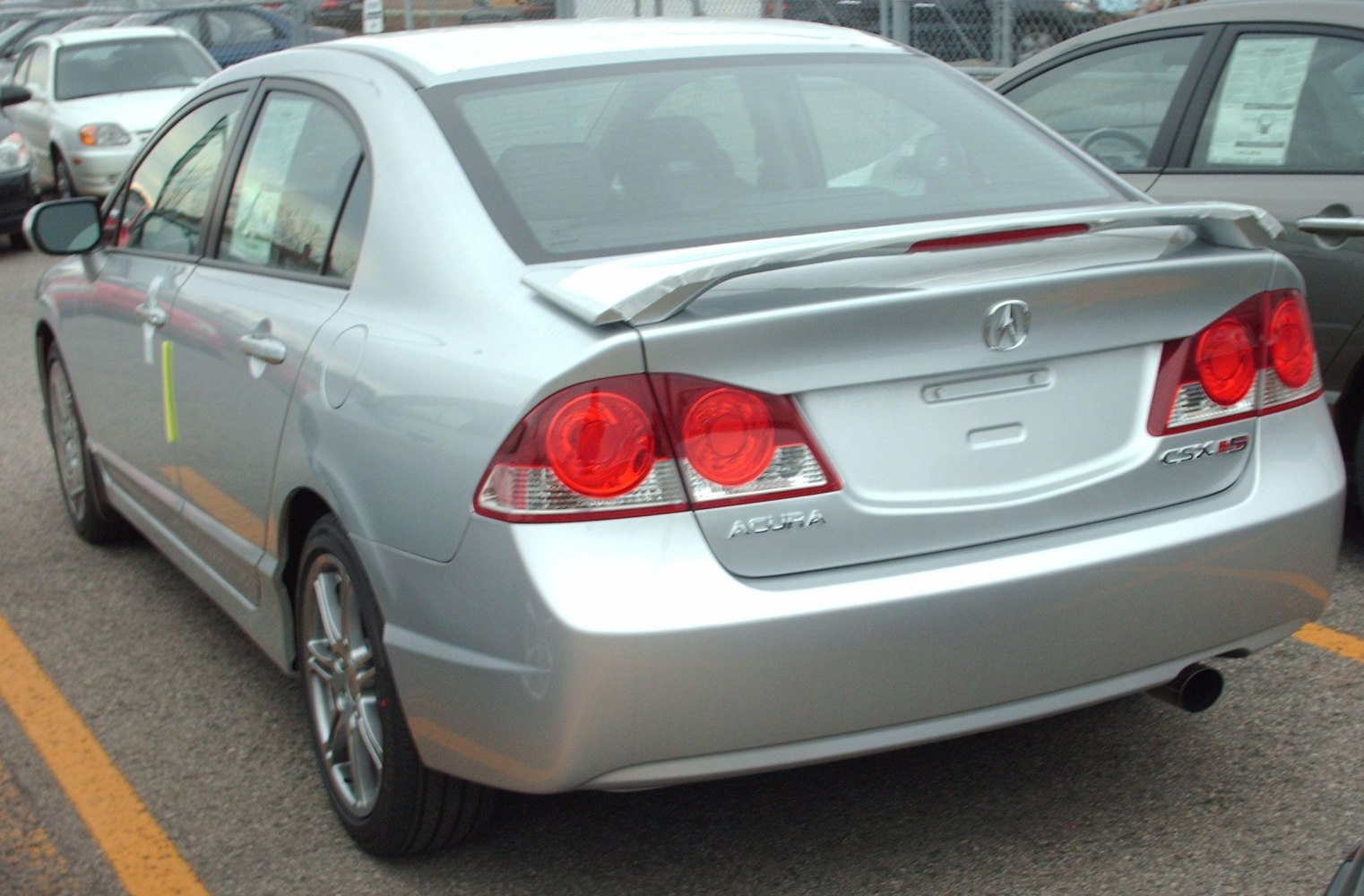 Rear spoiler and distinctive tail lights on a silver sedan.
