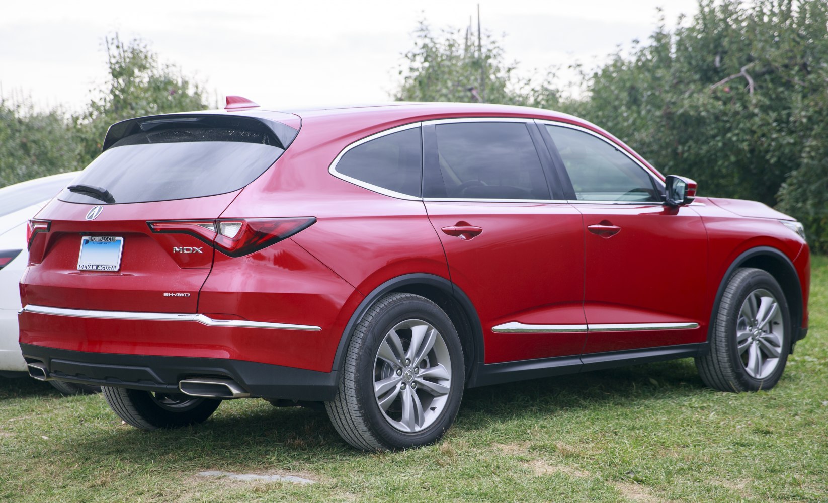 Rear side profile of red SUV with tail lights and alloy wheels.