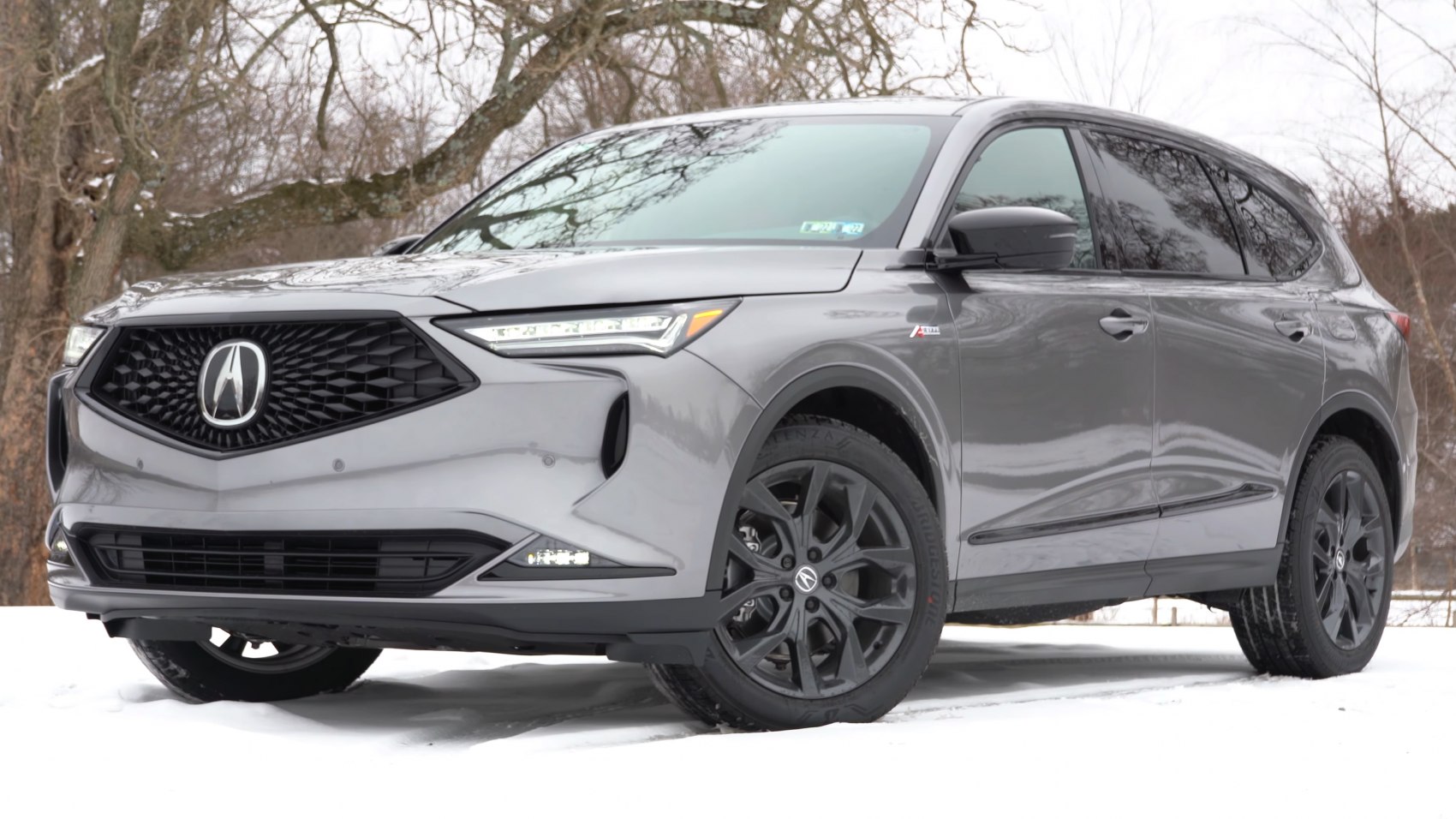 Front grille and black alloy wheels of an SUV in snow