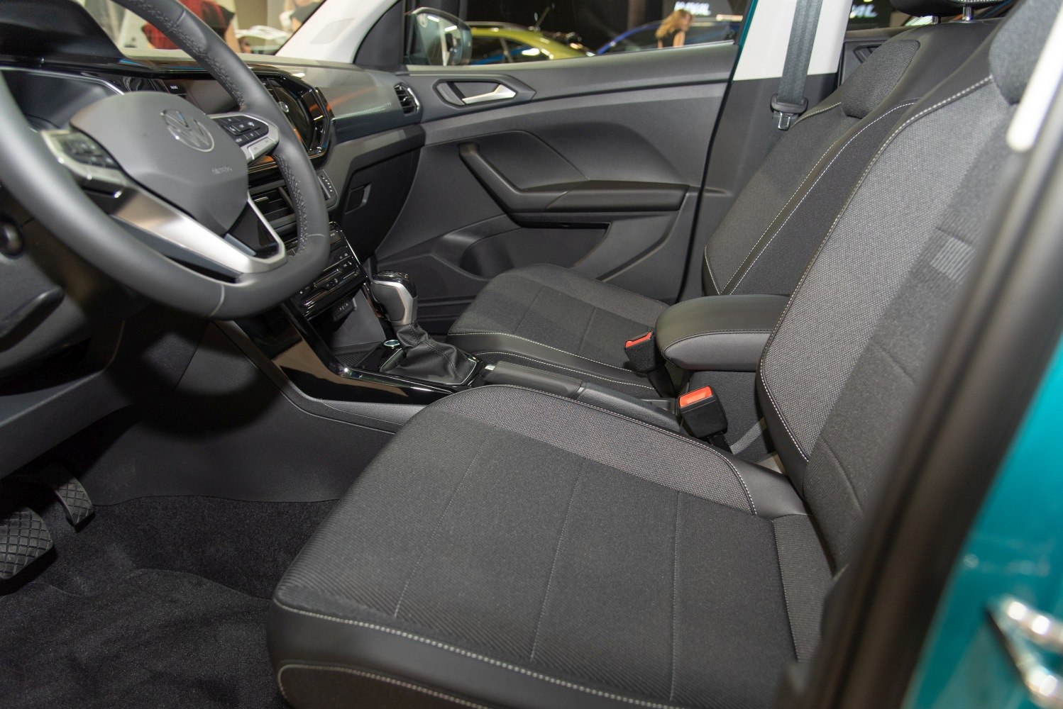 Modern car interior with dashboard, steering wheel, and fabric seats
