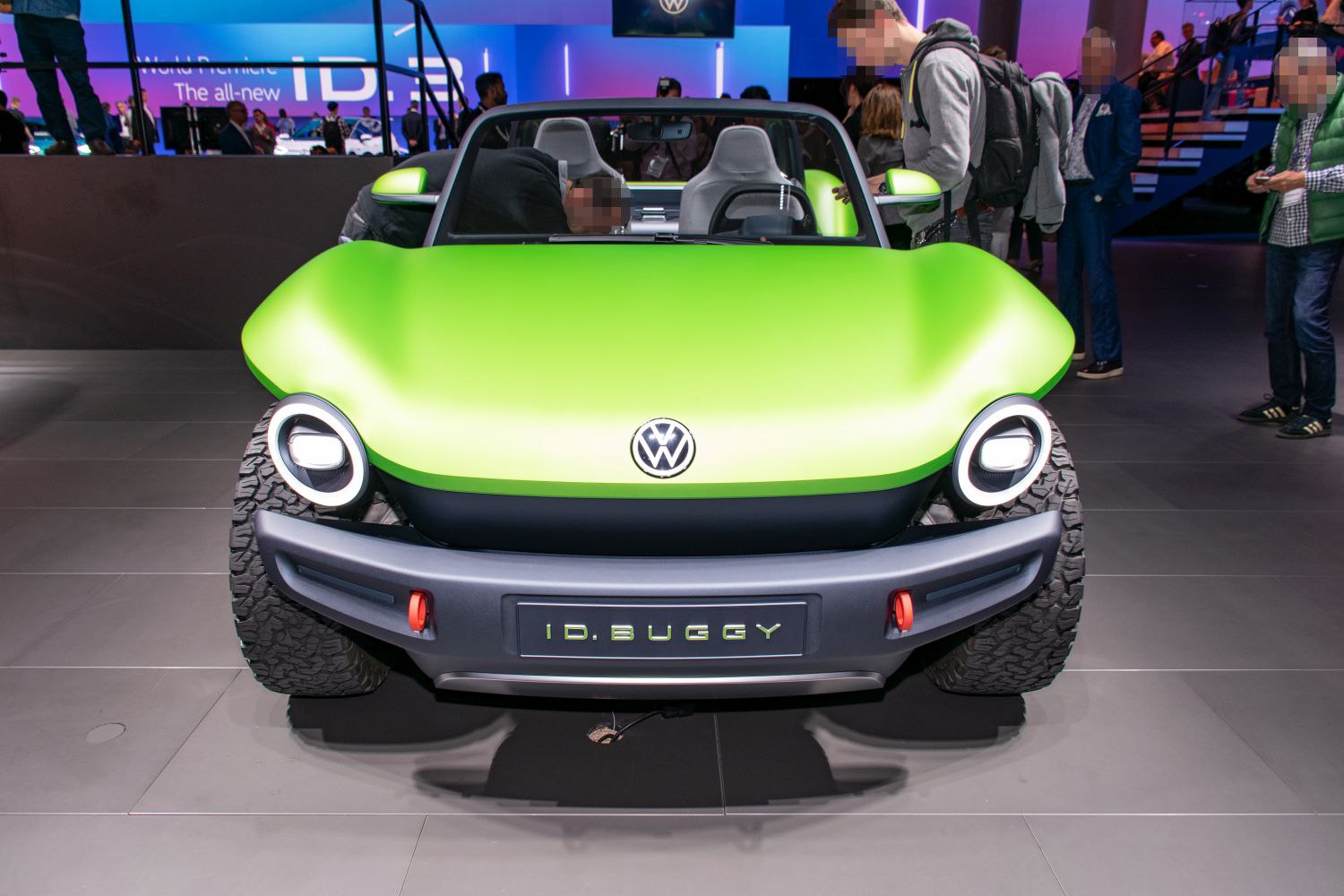 Front view of green Volkswagen with round LED headlights and rugged off-road tires