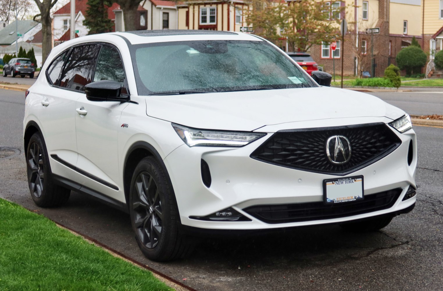 Front side view of a white SUV with black grille and LED headlights