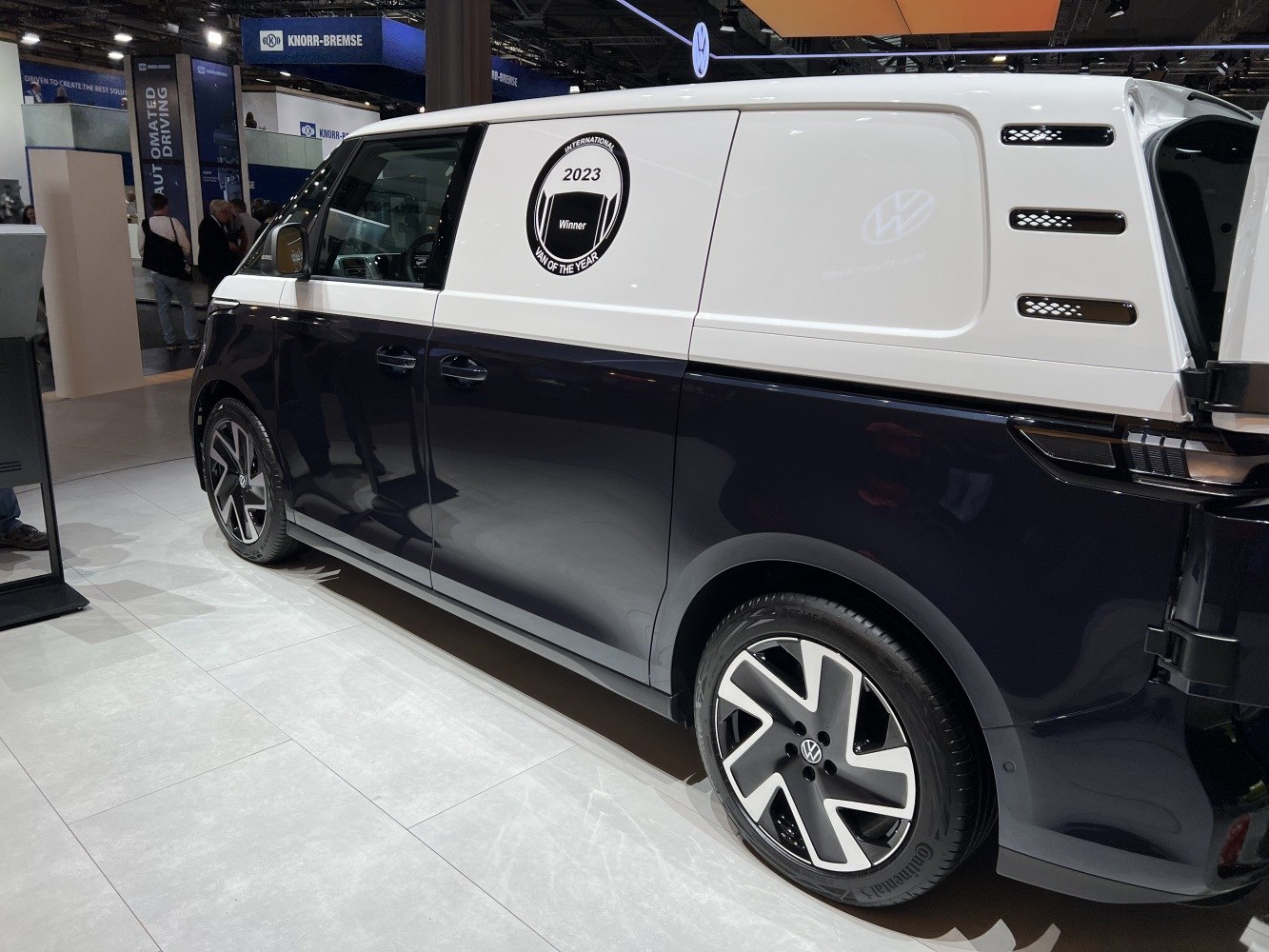 Side view of an electric cargo van with alloy wheels and side ventilation grilles