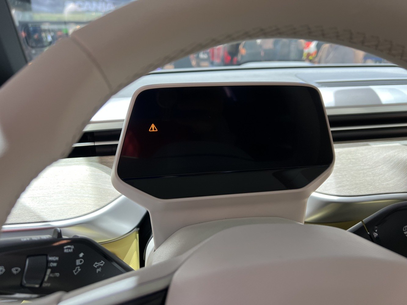 Digital instrument cluster and steering wheel controls with warning icon