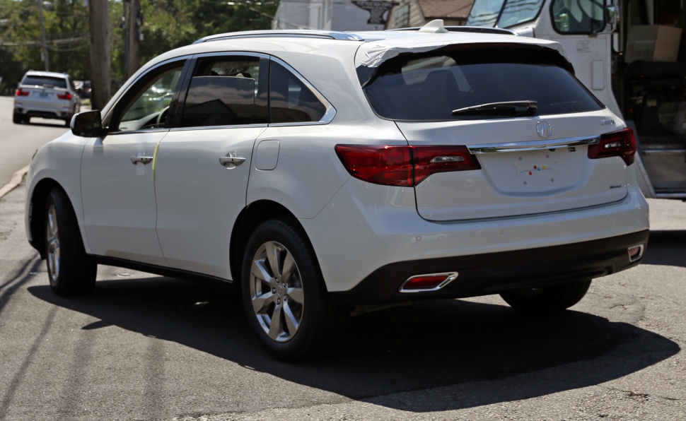 Rear-side view of mid-size SUV with tinted windows and dual exhausts