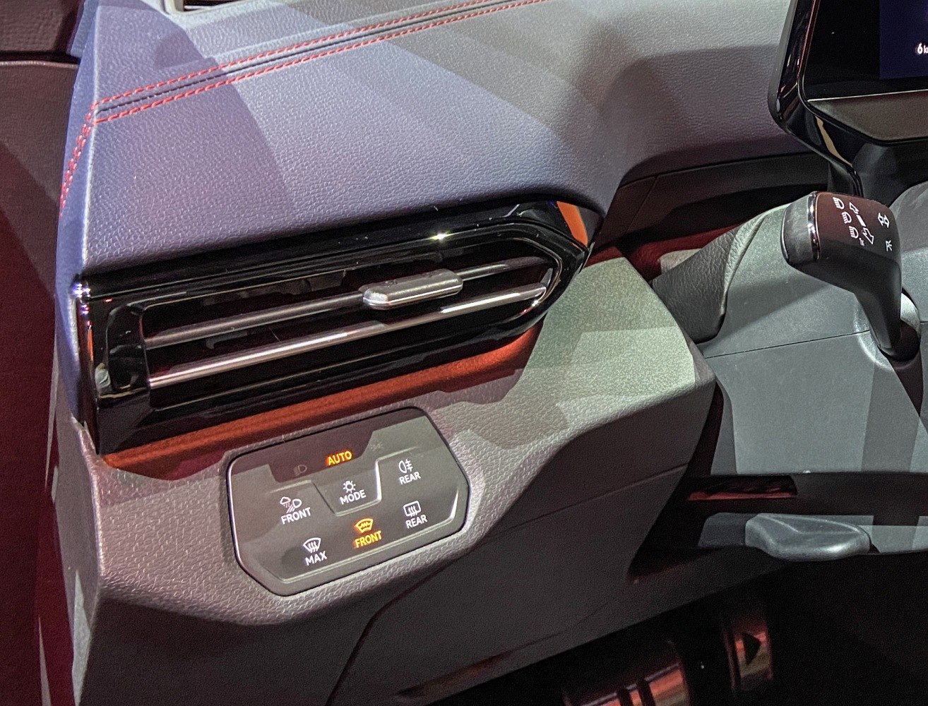 Interior air vent with red stitching and digital climate control panel