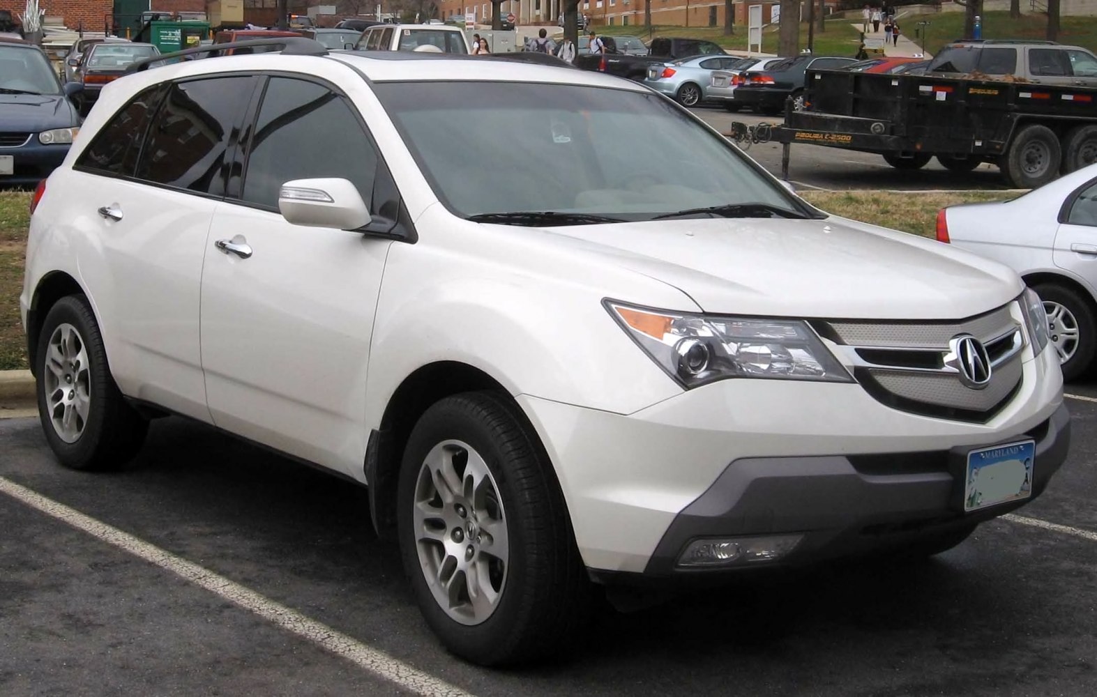 Front three-quarter view of a white SUV with detailed grille and headlights