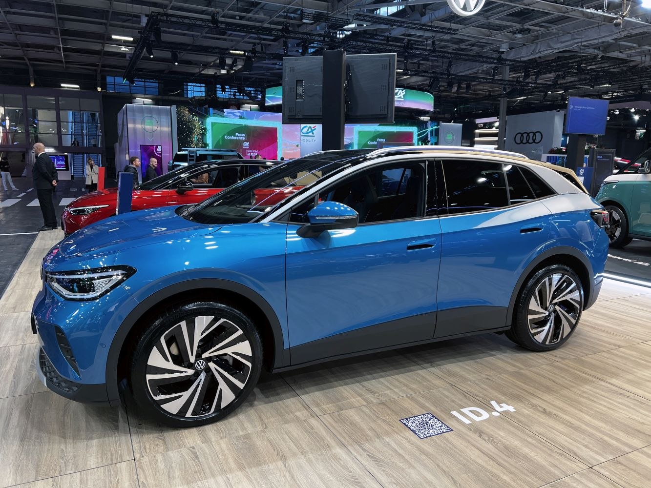 Blue electric SUV with aerodynamic shape and modern alloy wheels, side profile view