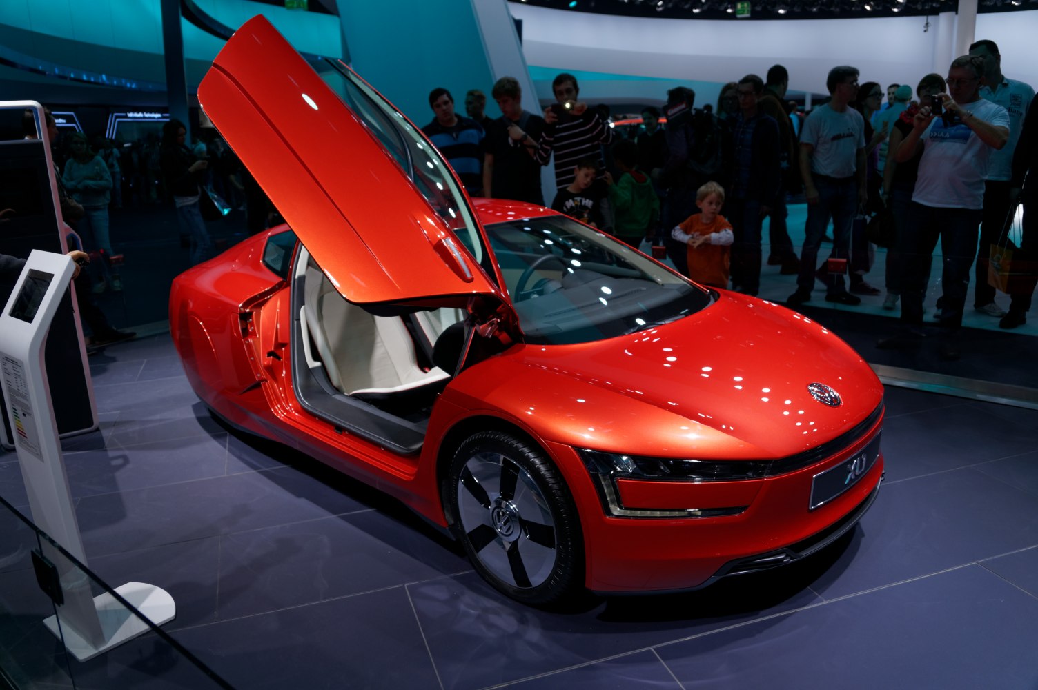 Red car with butterfly doors open, showcasing sleek aerodynamic design